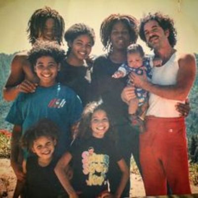 All of them are posing together with Joel holding the smallest one of the kids.